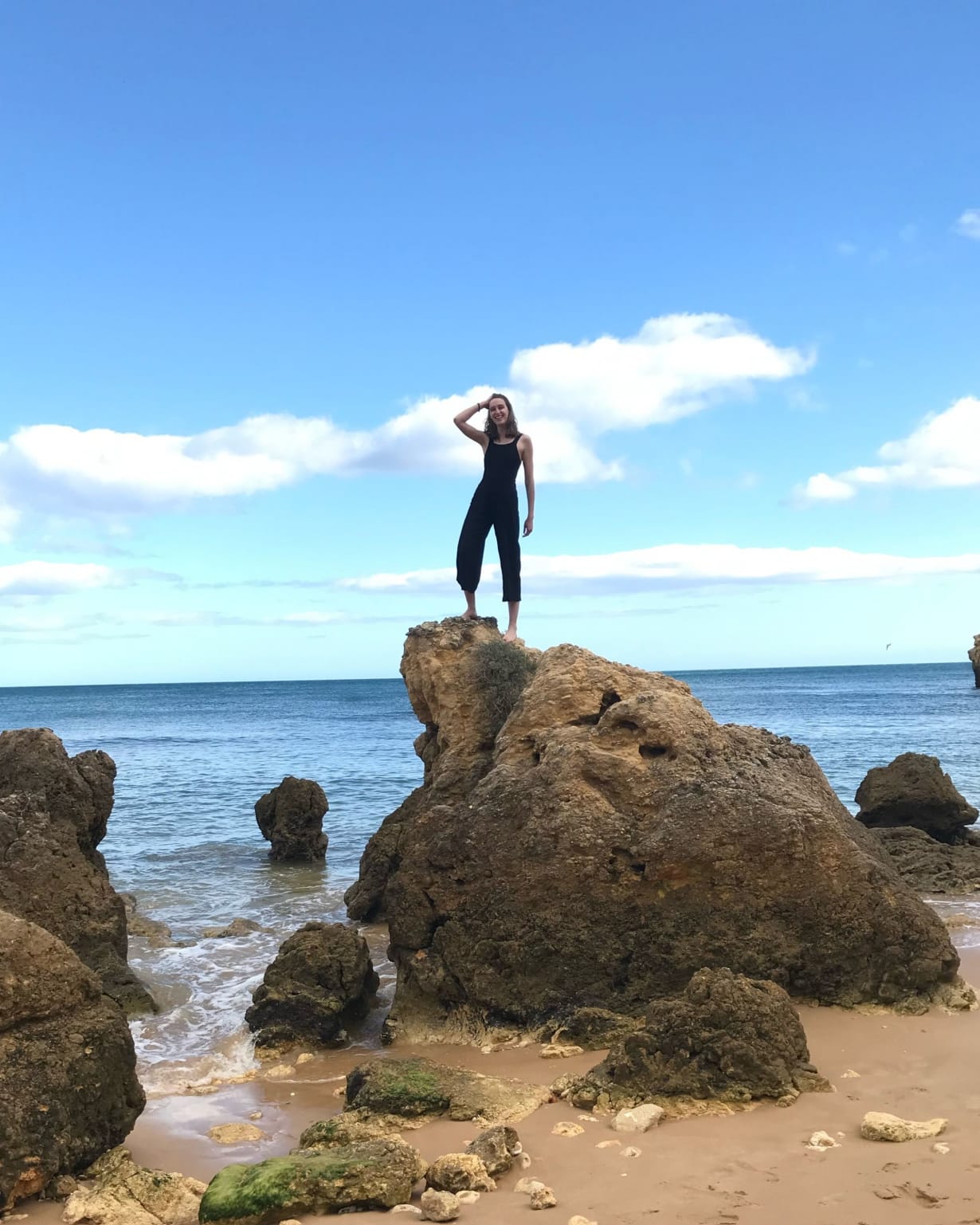 Dr. Carina Graham stands on top of rock with the sea behind her