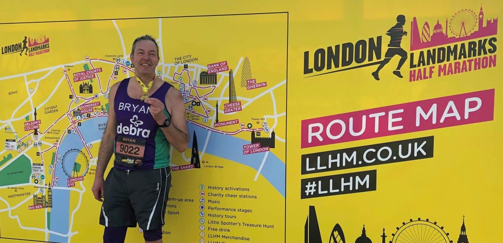#TeamDEBRA runner in front of a London Landmarks Half Marathon banner