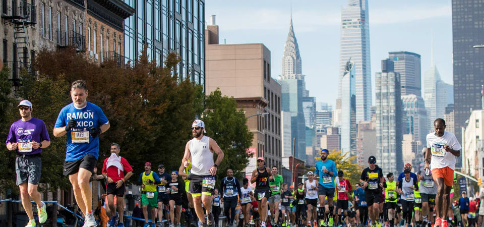 Crowd of runners run through New York City.