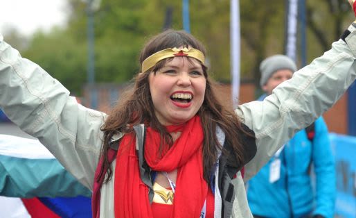 Participant of the Kiltwalk raising her arms and smiling