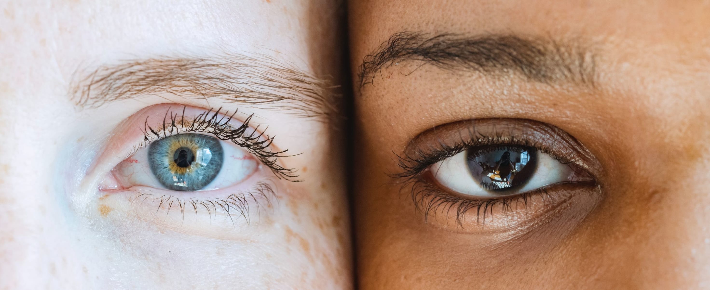 Close up of the eyes of two people of different ethnic backgrounds.