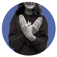 Young woman is showing the sign language symbol for butterfly (hands with thumbs together and palms facing in)