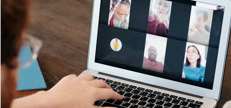 Woman joins a Zoom video call with a group of people on her laptop