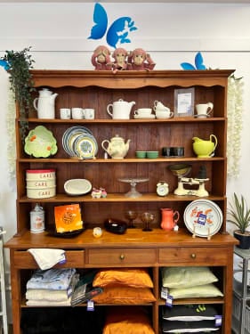 Wooden cabinet with bric-a-brac items on display at DEBRA Lightwater.