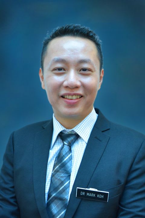 Dr Mark Koh: Man in a suit and tie smiling at the camera.