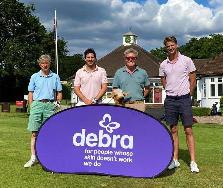 4 golf players in front of a DEBRA banner