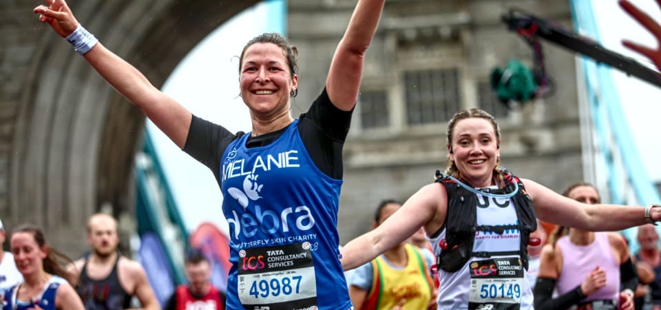 Melanie runs across tower bridge with her arms in the air